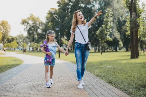 Blonde-haired woman showing her daughter nice place