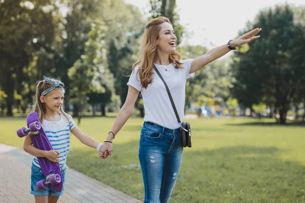 Stylish mother wearing cross shoulder bag having a walk with daughter — Stock Photo, Image