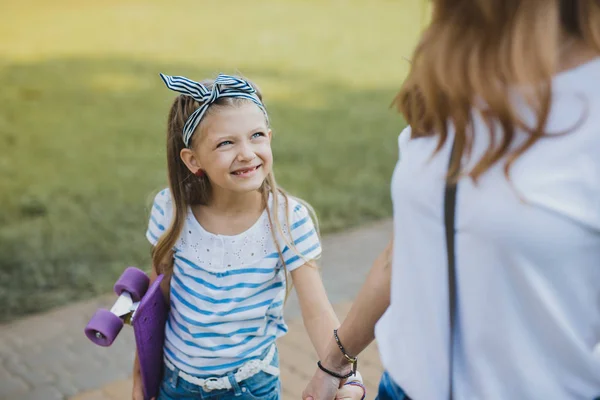 Мила блакитноока дівчина дивиться на свою матір під час прогулянки разом — стокове фото