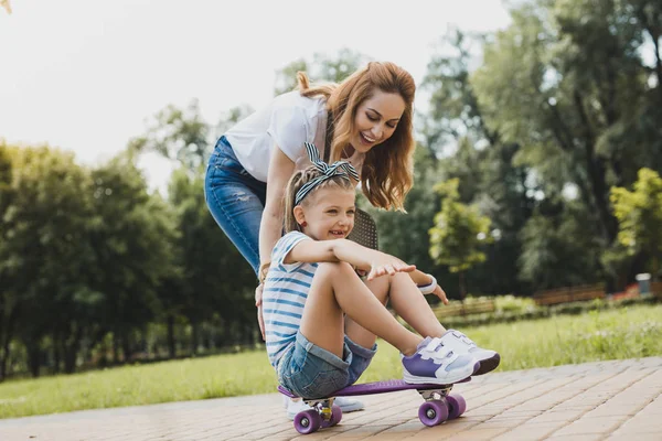 Young loving mother watching her active girl — Stock Photo, Image