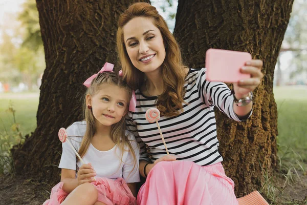 Moderna madre amorosa haciendo selfie con linda hija —  Fotos de Stock