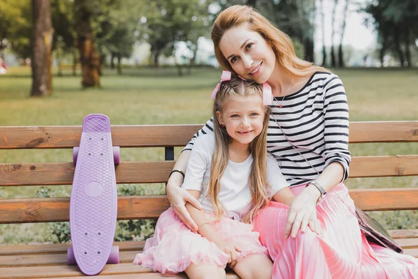 Rubia de pelo madre y su hija sentado en el banco en el parque —  Fotos de Stock