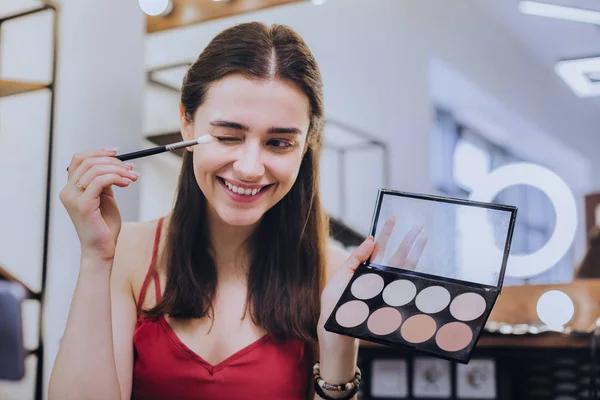 Mujer radiante sosteniendo cepillo de ojos mientras se prepara para la fecha — Foto de Stock