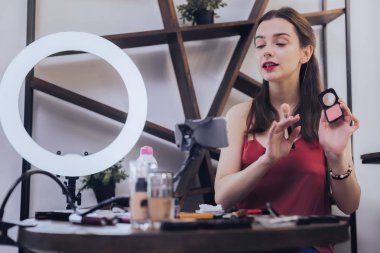 Video sohbet yaparken onun yüz pudrası kullanan meşgul kadın