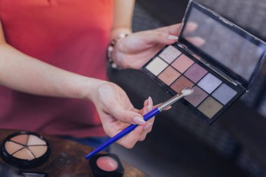 Bej kadınla göz tonları kullanarak giyen kırmızı bluz çivi