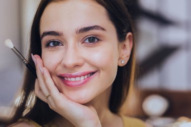 Güzel duygu. Çok güzel bir esmer kadın geniş aynaya bakarken güzel duygu gülümseyen