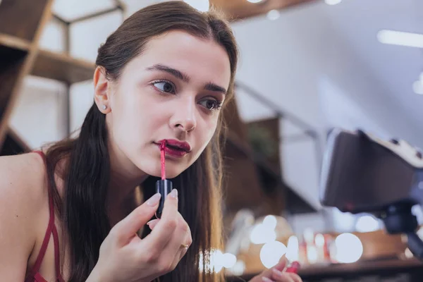 Encantadora mujer de pelo oscuro para colorear sus labios — Foto de Stock