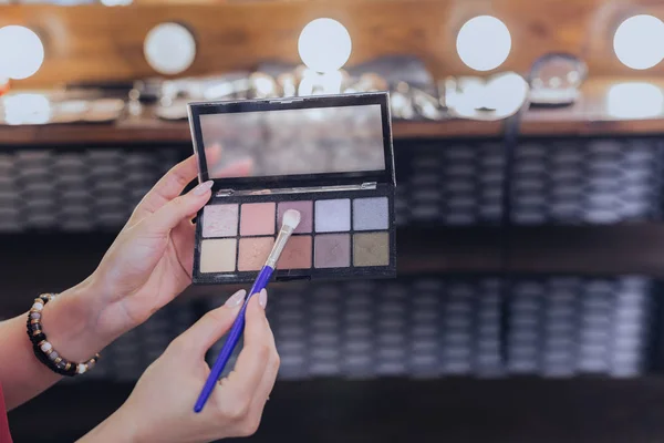 Makeup artist holding little makeup brush in her hand — Stock Photo, Image