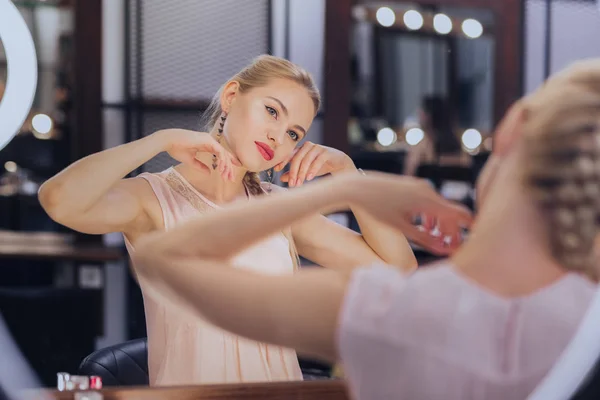 Mooie blonde-haired vrouw nemen van verrukking in haar mooie make-up — Stockfoto