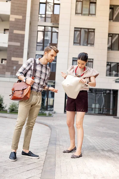 Mujer joven sin animadoras mirando en su bolso — Foto de Stock