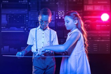 İnce bir aygıt ve sakin bir kız ona işaret tutan dikkatli çocuk