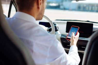 Onun smartphone kullanarak profesyonel erkek sürücü