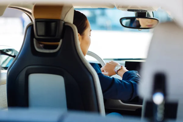 Bonita joven sentada detrás del volante — Foto de Stock