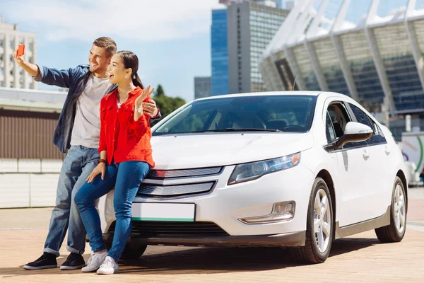 Радісний щасливу пару стоїть біля свого автомобіля — стокове фото