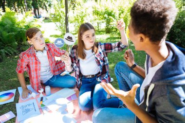 Genç sarışın öğrenci beyaz düşünme şapka kullanarak kızgın hissediyor
