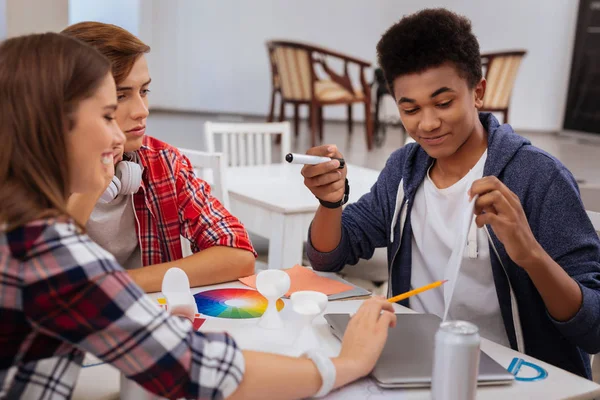 Stilvoller dunkelhaariger Student verbringt seine Pause mit Klassenkameraden — Stockfoto