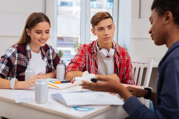 Blondhaarige Studentin mit Kopfhörern sitzt mit Klassenkameraden zusammen — Stockfoto