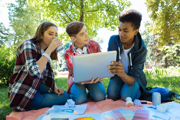 Blonde-Haired posztgraduális munkáját mutatja a laptop — Stock Fotó