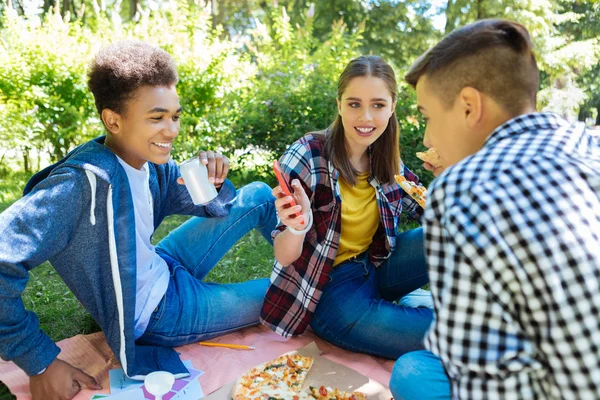 Empresa de três jovens personalidades que almoçam na natureza — Fotografia de Stock