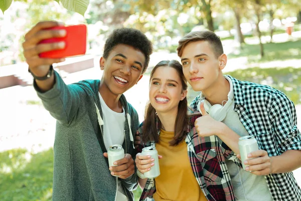 Trasportando gli studenti dai capelli scuri che tengono il suo smart phone rosso — Foto Stock