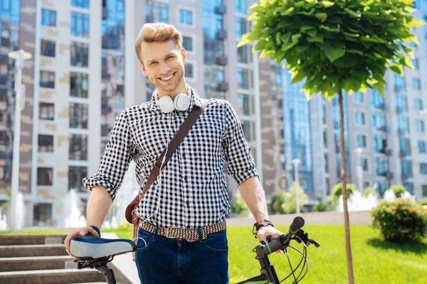 Agradable buen hombre sosteniendo su bicicleta — Foto de Stock