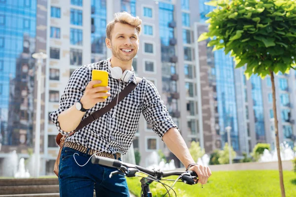 Positiv schöner Mann hält sein Smartphone — Stockfoto