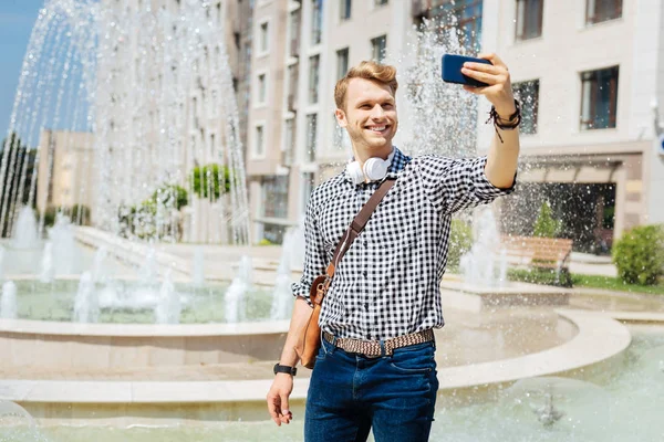 Lycklig stilig man tar en selfie — Stockfoto