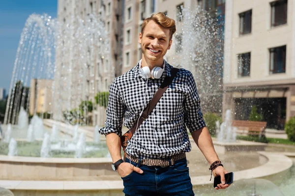 Joyful stilig man hålla sin smartphone — Stockfoto