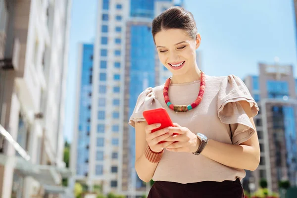 Joven alegre usando su teléfono inteligente — Foto de Stock