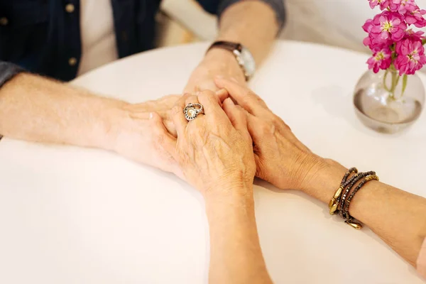 Руки старшего мужчины и женщины держатся вместе — стоковое фото