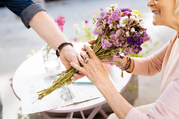 Зрелые женские руки, хватающие цветы — стоковое фото