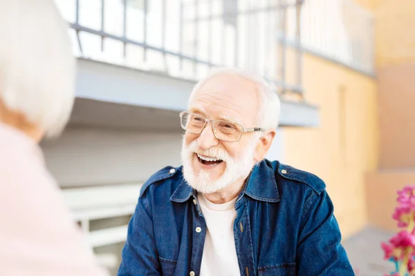 Веселый пожилой мужчина разговаривает с женой — стоковое фото