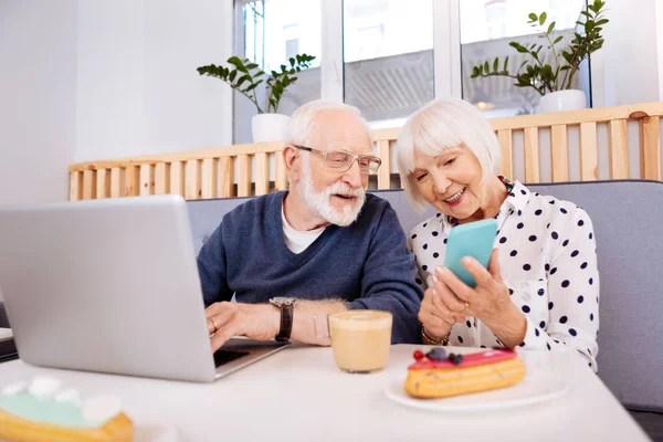 Aangename senior paar met vermelding van op telefoon — Stockfoto