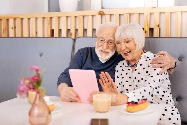 Joyful senior couple making online call