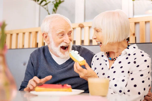 Veselý senior člověk přijímající Eclair — Stock fotografie