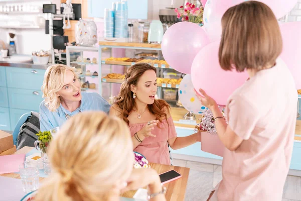 Mörkhårig kvinna med kort frisyr presenterar air ballonger och box — Stockfoto