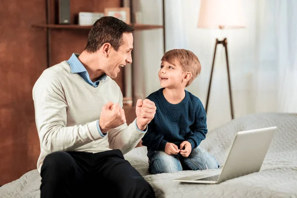 Szczęśliwy pozytywny człowiek ogląda jego syn — Zdjęcie stockowe