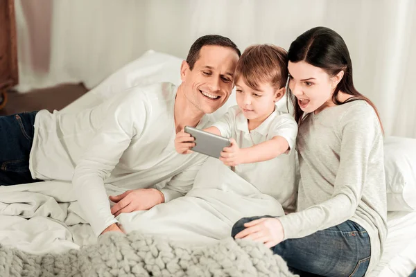 Alegre chico lindo sosteniendo un teléfono inteligente — Foto de Stock