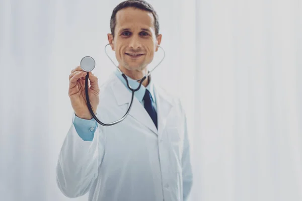 Joyful doctor demonstrating his instrument — Stock Photo, Image