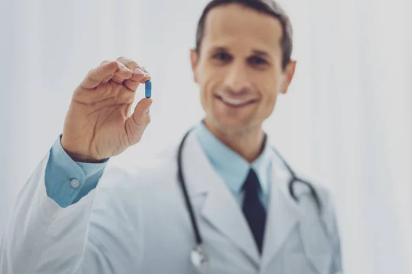 Handsome medical worker recommending little pill