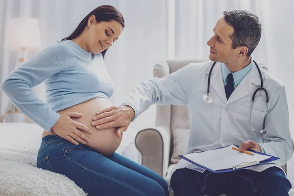 Unga graviditeten sitter nära hennes läkare — Stockfoto