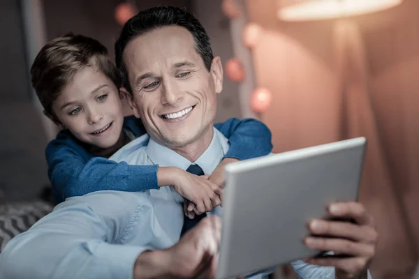 Portret uśmiechnięty chłopiec, który obejmując jego tata — Zdjęcie stockowe