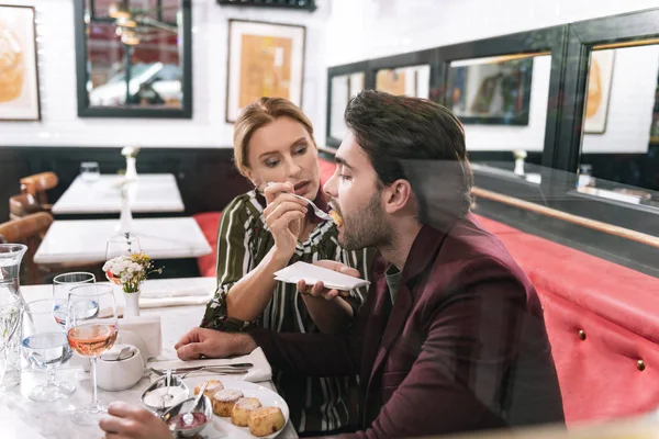 Mooie rijpe vrouw geven voedsel voor de mens — Stockfoto