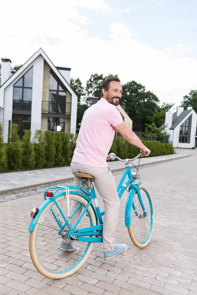 Encantado buen hombre montando su bicicleta — Foto de Stock