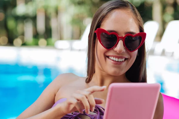 Femme portant des lunettes de soleil rouge vif message de lecture sur son ordinateur portable — Photo