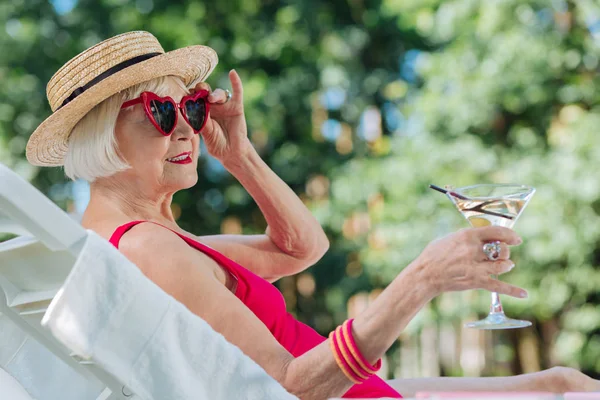 Grande-mère aux cheveux blonds portant un chapeau élégant relaxant à l'extérieur — Photo