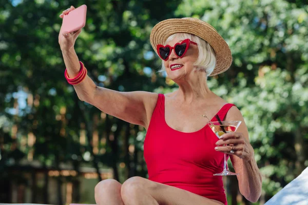 Stralende blonde-haired volwassen vrouw maken foto met martini — Stockfoto