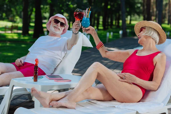 Succesvolle gepensioneerde man en vrouw koelen in de buurt van buiten zwembad — Stockfoto