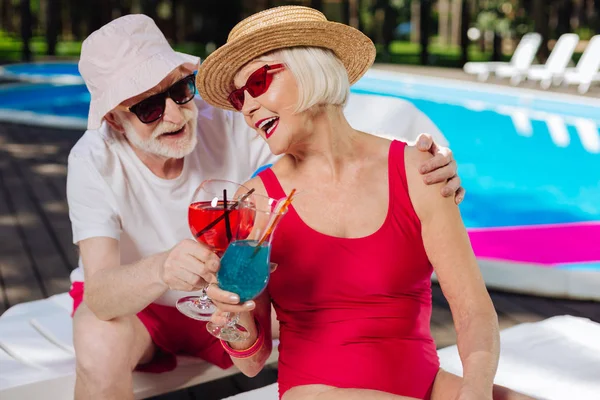 Blonde-haired gepensioneerde vrouw luisteren naar grappen van haar man — Stockfoto