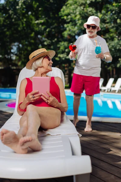 Femme retraitée allongée sur une chaise longue attendant des cocktails — Photo